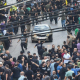 People run for cover after a blast sounded during a funeral in south Beirut for those killed in pager explosions the day before